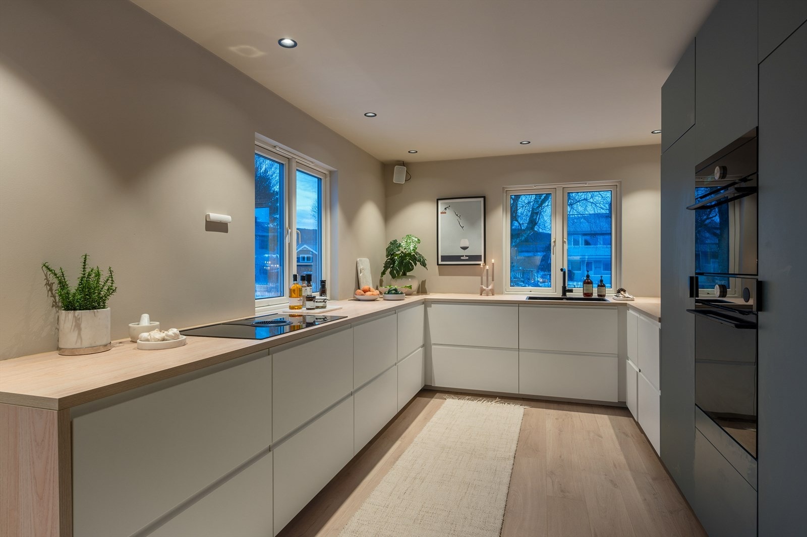 Romslig kjøkken på 10,5 m² med integrerte hvitevarer i stilrent, sort design. Galleribilde