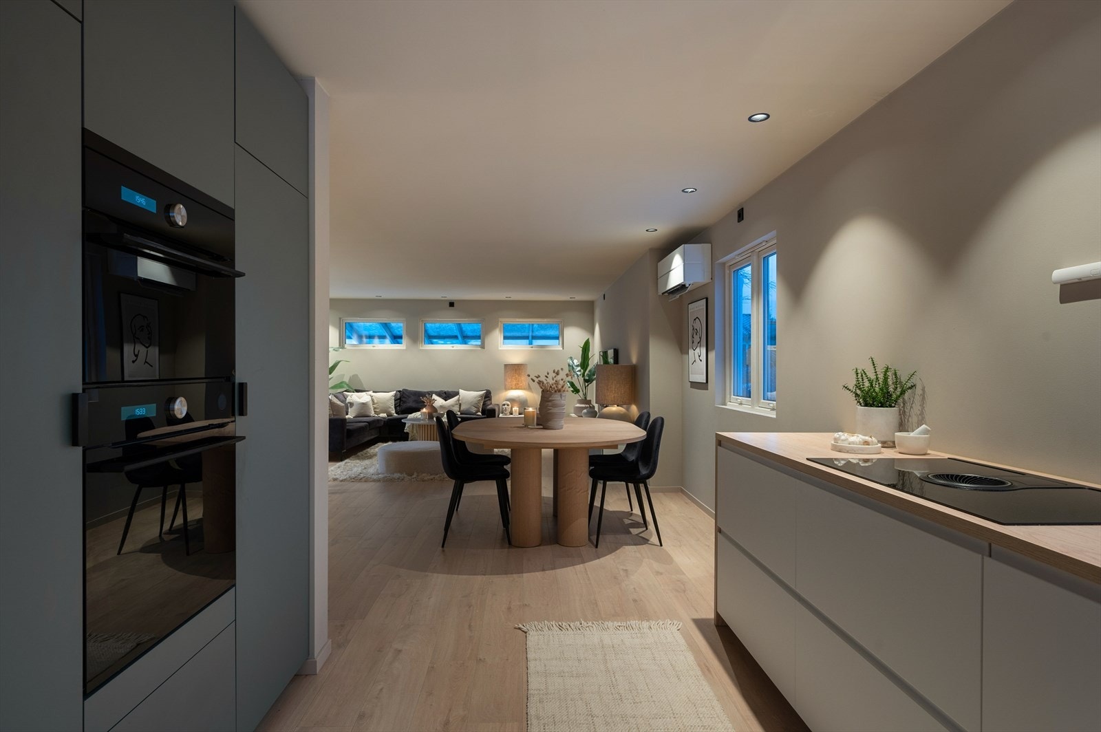 De mørkere høyskapene står i elegant kontrast til den lyse benkeplaten og skuffefrontene. Galleribilde