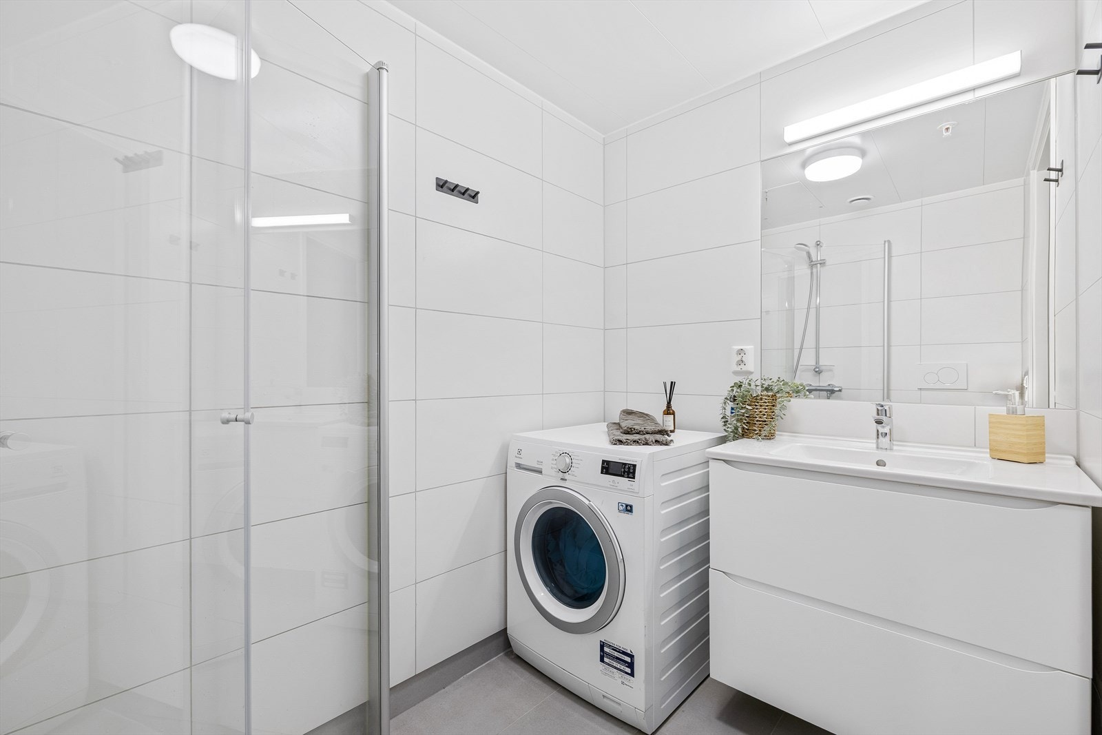 Baderommet er utstyrt med nedfelt servant, toalett og opplegg for vaskemaskin og fremstår funksjonelt og moderne. Galleribilde