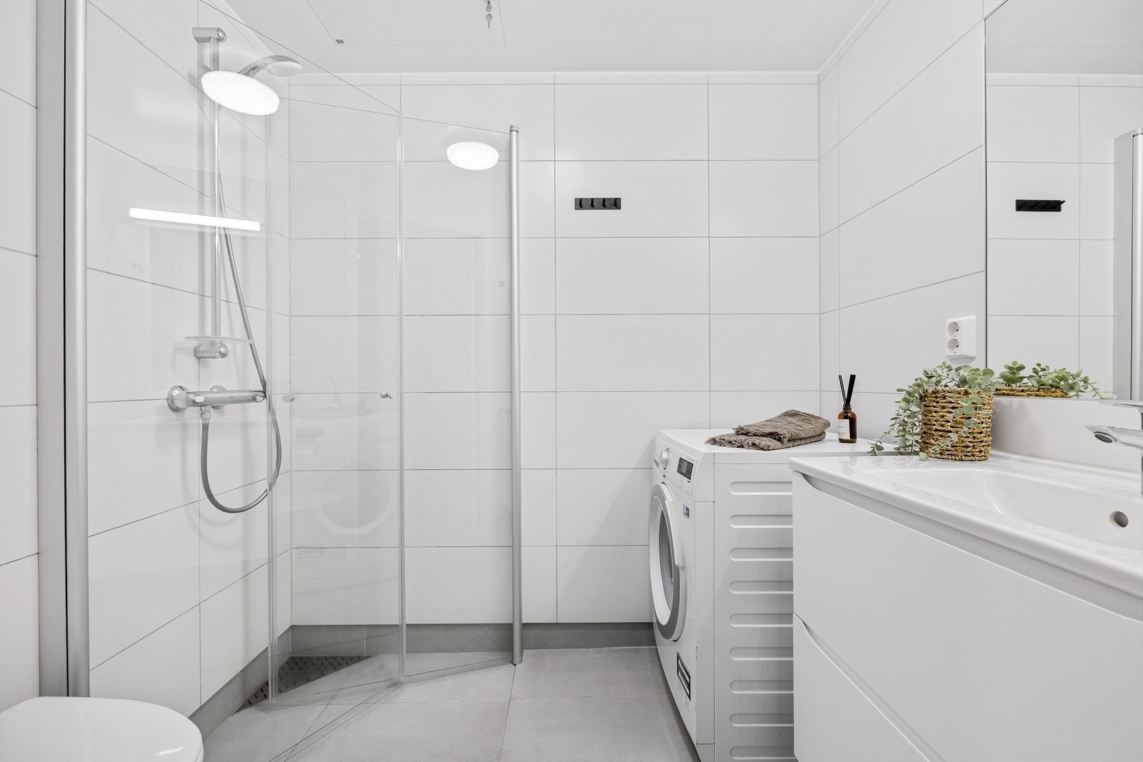 Delikat baderom på ca. 3,1 m² med flislagt gulv, dusjhjørne og elektriske varmekabler. Galleribilde