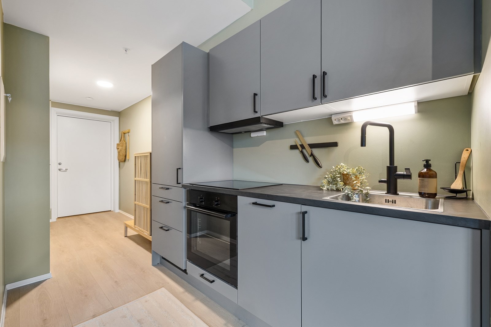 Kjøkkenet har moderne fargevalg med slette fronter i en tidløs gråfarge samt godt med skap og benkeplass. Galleribilde