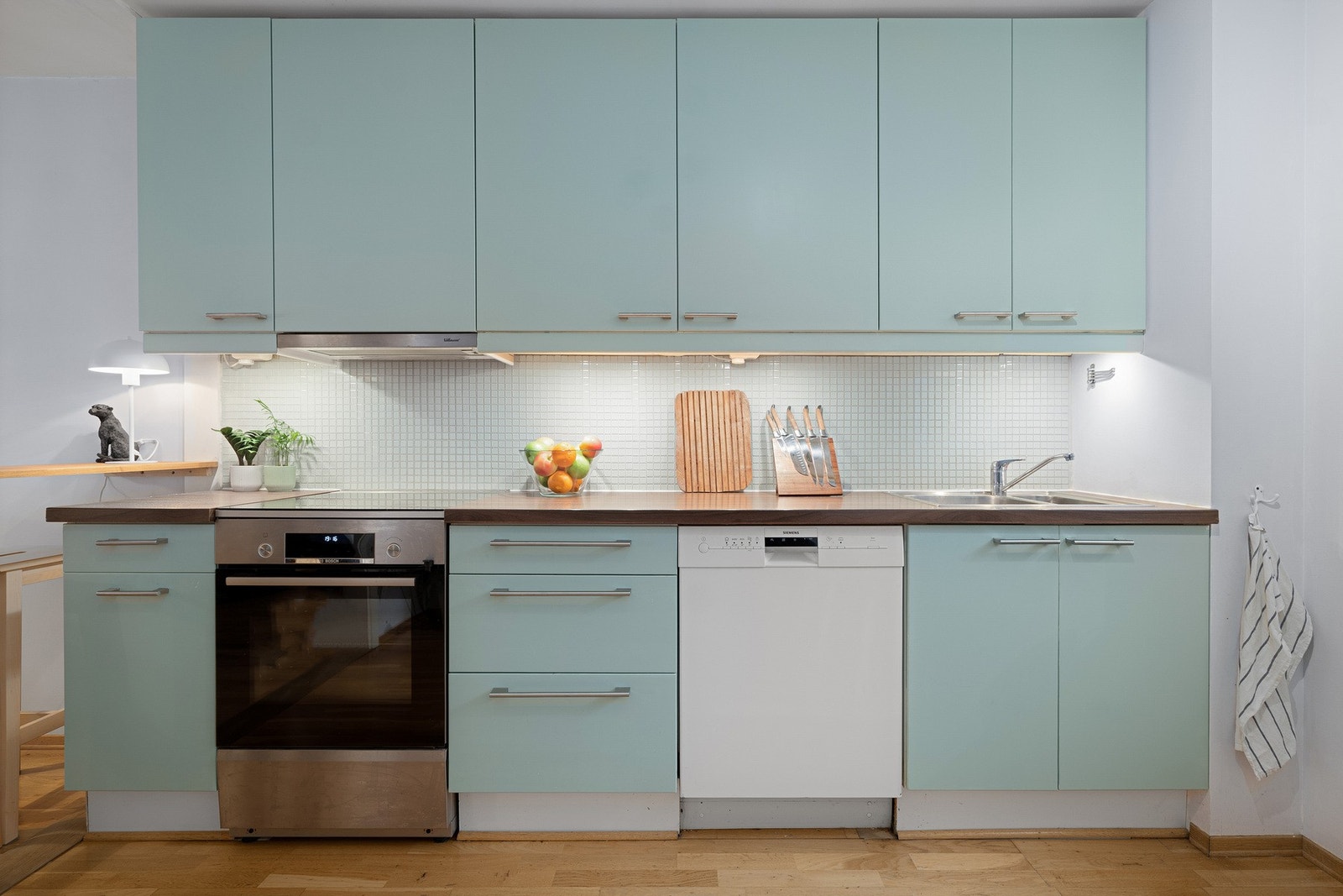 Over benkeplaten er det lagt mosaikkfliser som tilfører struktur uten å dominere. Galleribilde