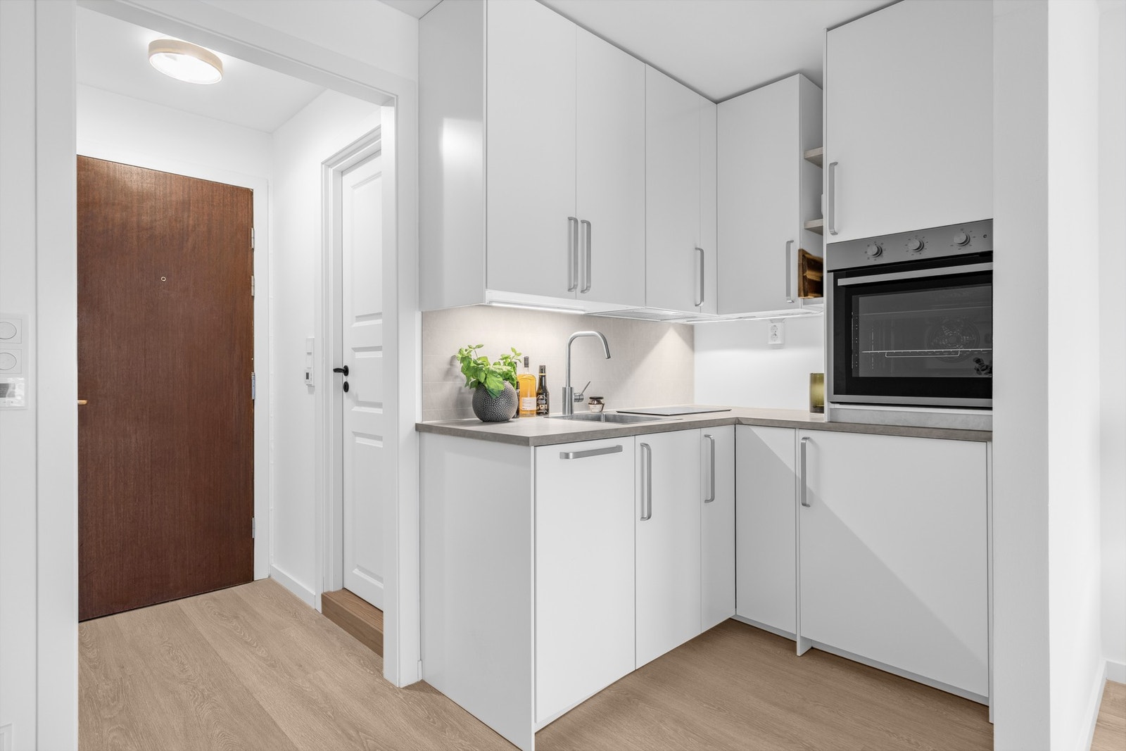 Integrerte hvitevarer med stekeovn, platetopp, oppvaskmaskin og kjøleskap med fryser gir et gjennomført og ryddig kjøkken. Galleribilde