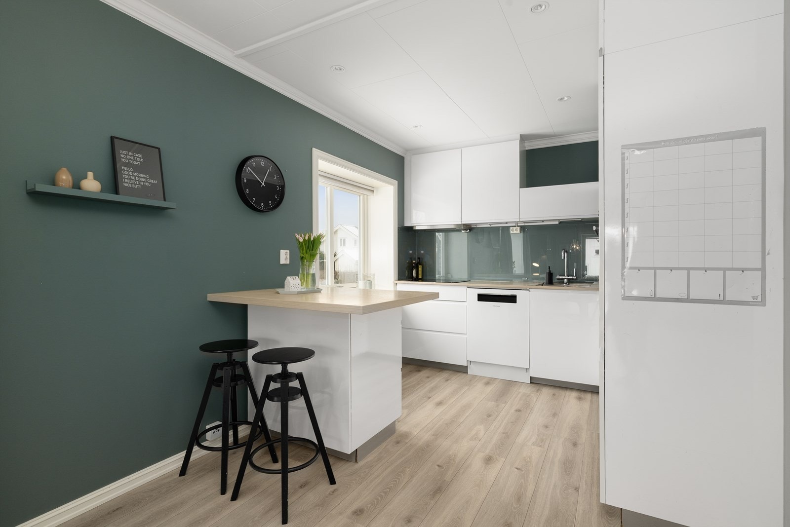 Laminat benkeplate med gode arbeidsflater, nedfelt platetopp og stålvask. Beskyttelsesplate i glass montert på vegg mellom over- og underskap. Galleribilde