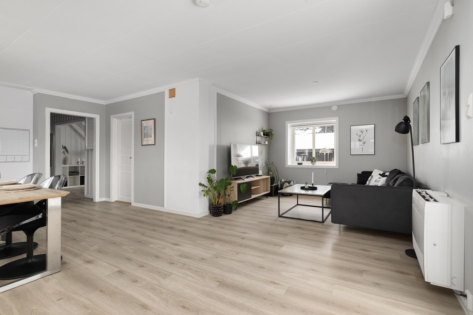 Romløsningen skaper fine soner for møblering, med god plass til sofagruppe og spisestue. Takessplater i tak, med innfelte spotter i kjøkkendel. Galleribilde