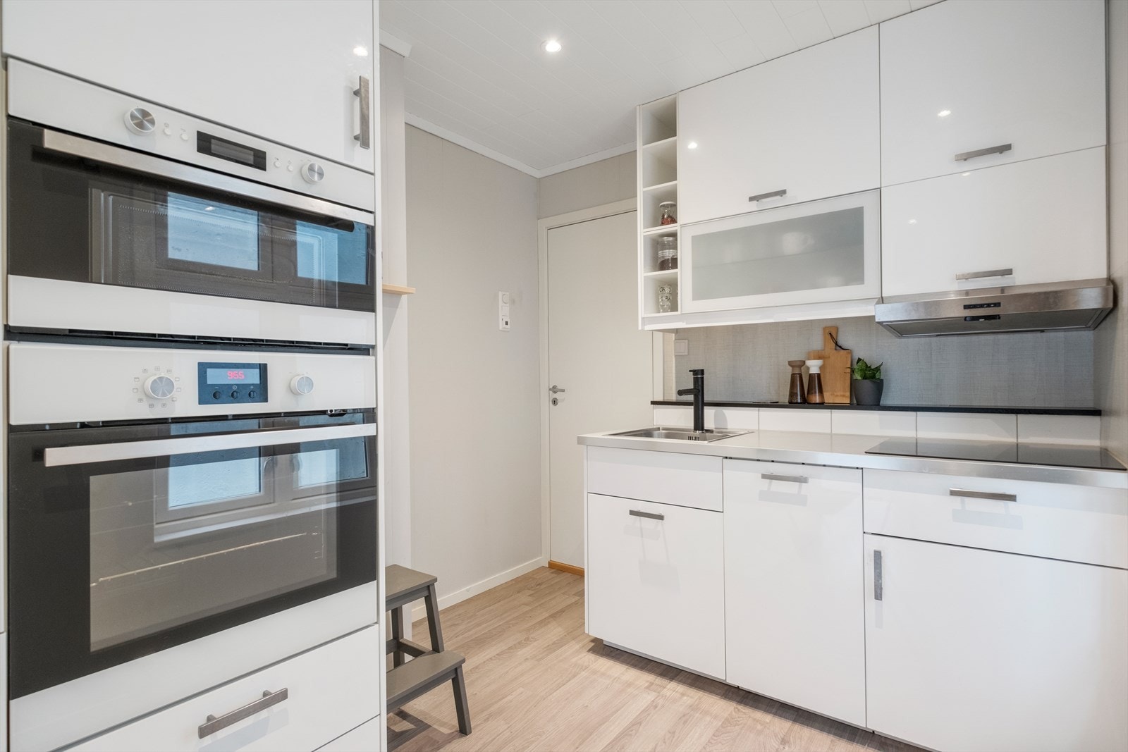 Lyst og pent kjøkken med integrerte hvitevarer. Galleribilde