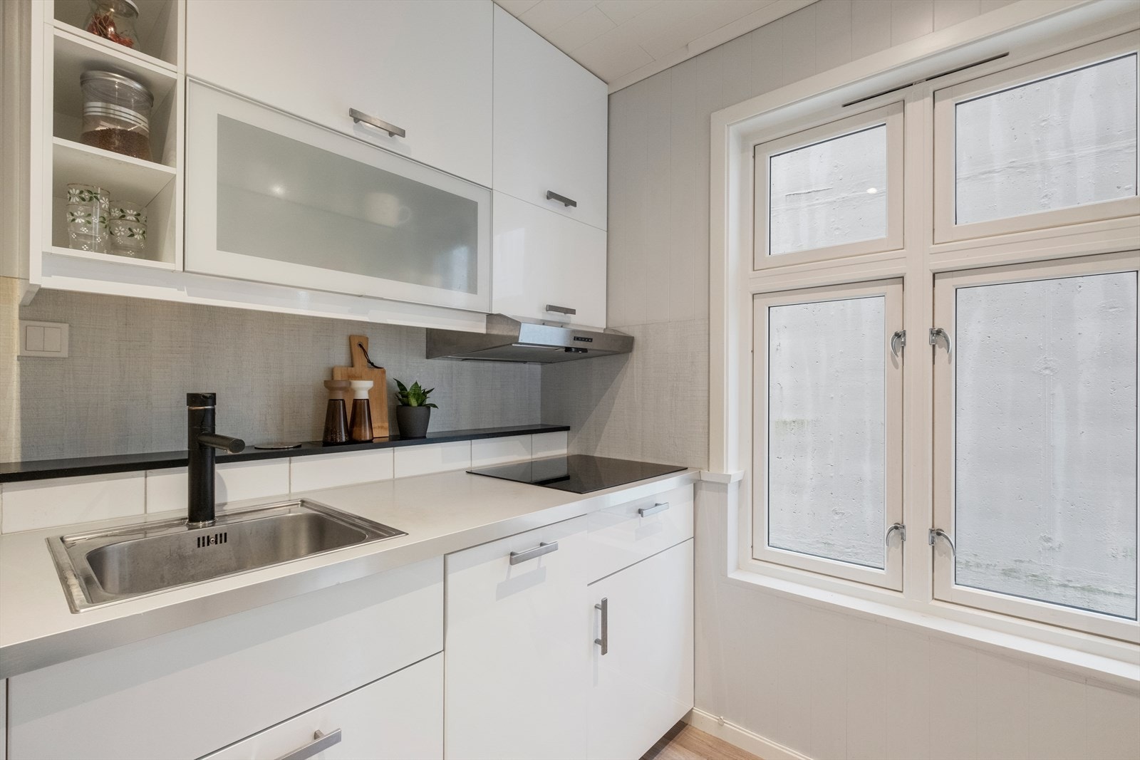 Lyst og pent kjøkken med integrerte hvitevarer. Galleribilde