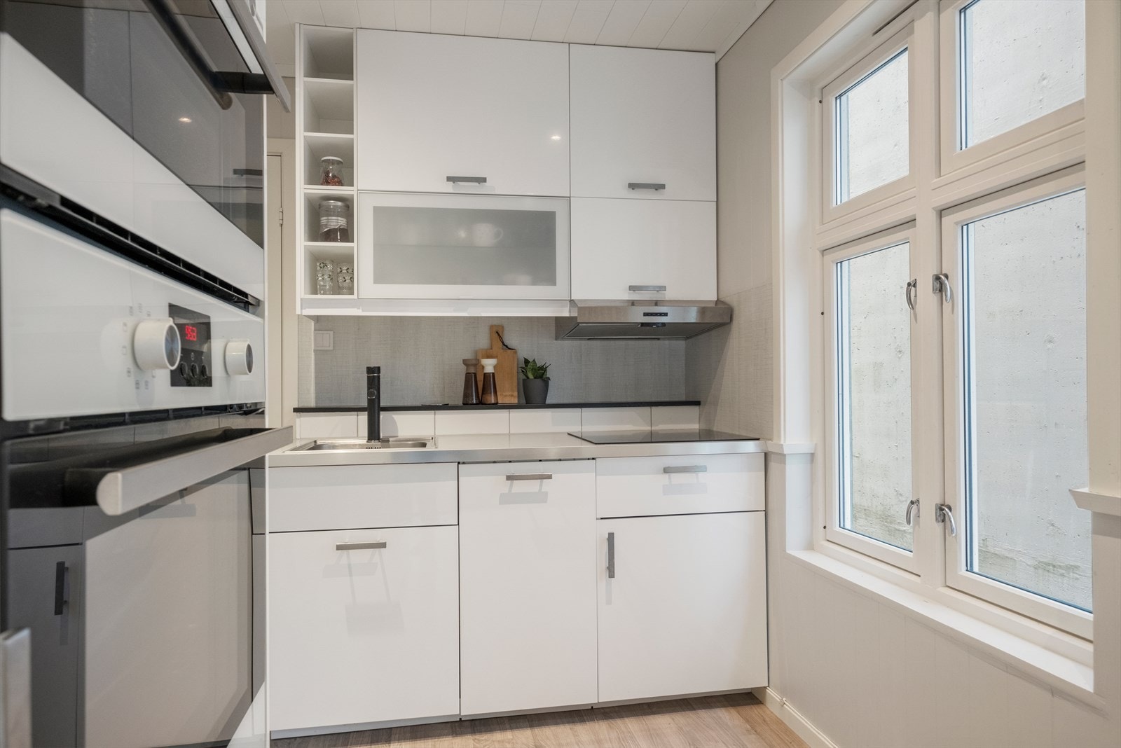 Lyst og pent kjøkken med integrerte hvitevarer. Galleribilde