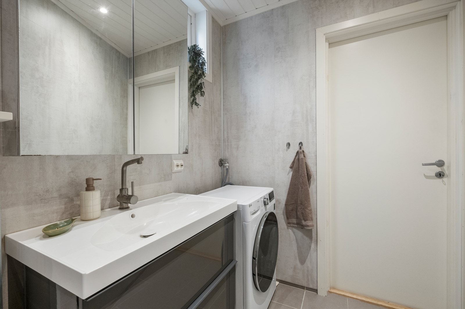 Pent og moderne bad med dusjkabinett, vegghengt toalett og plass til vaskemaskin. Galleribilde