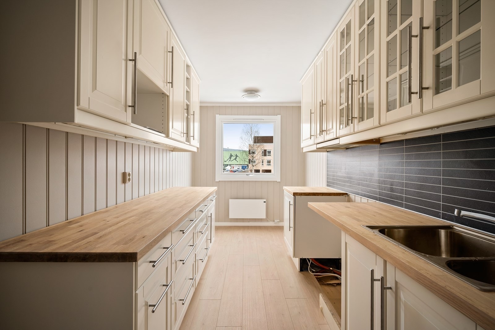 Moderne kjøkken med IKEA-innredning og heltre benkeplate. Galleribilde