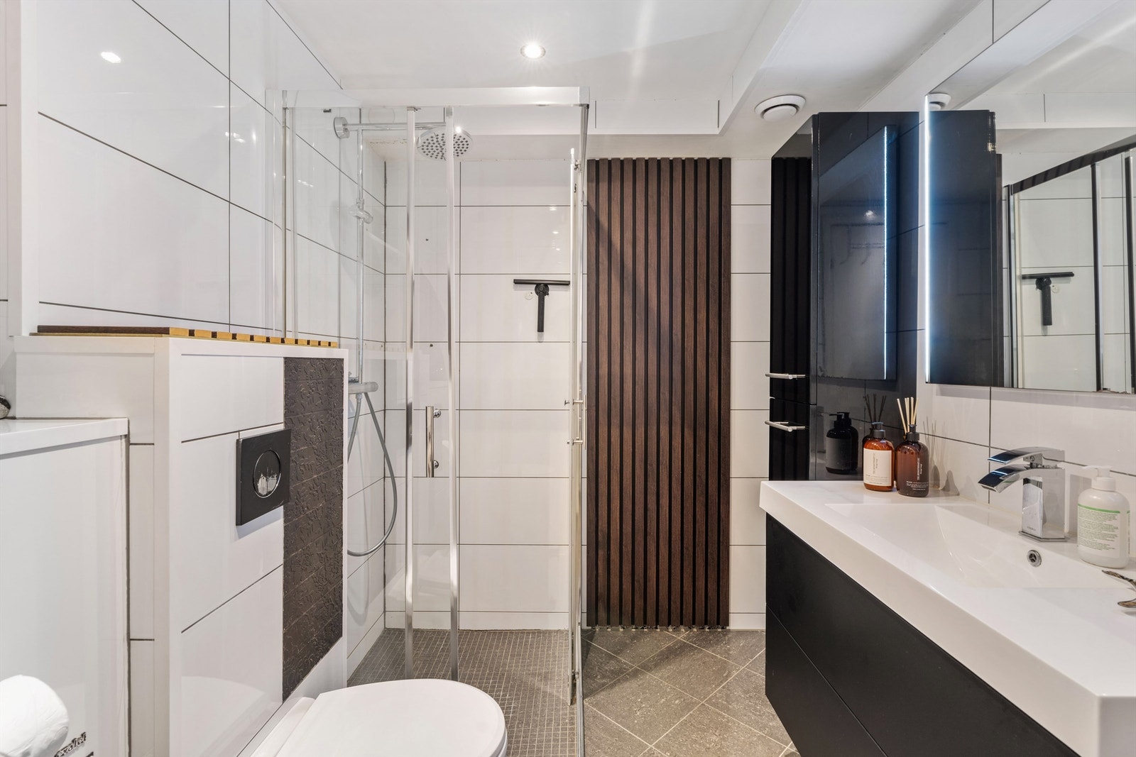 En stilig spilevegg og dusjhjørne med regnfallsdusj gir et moderne uttrykk. Galleribilde