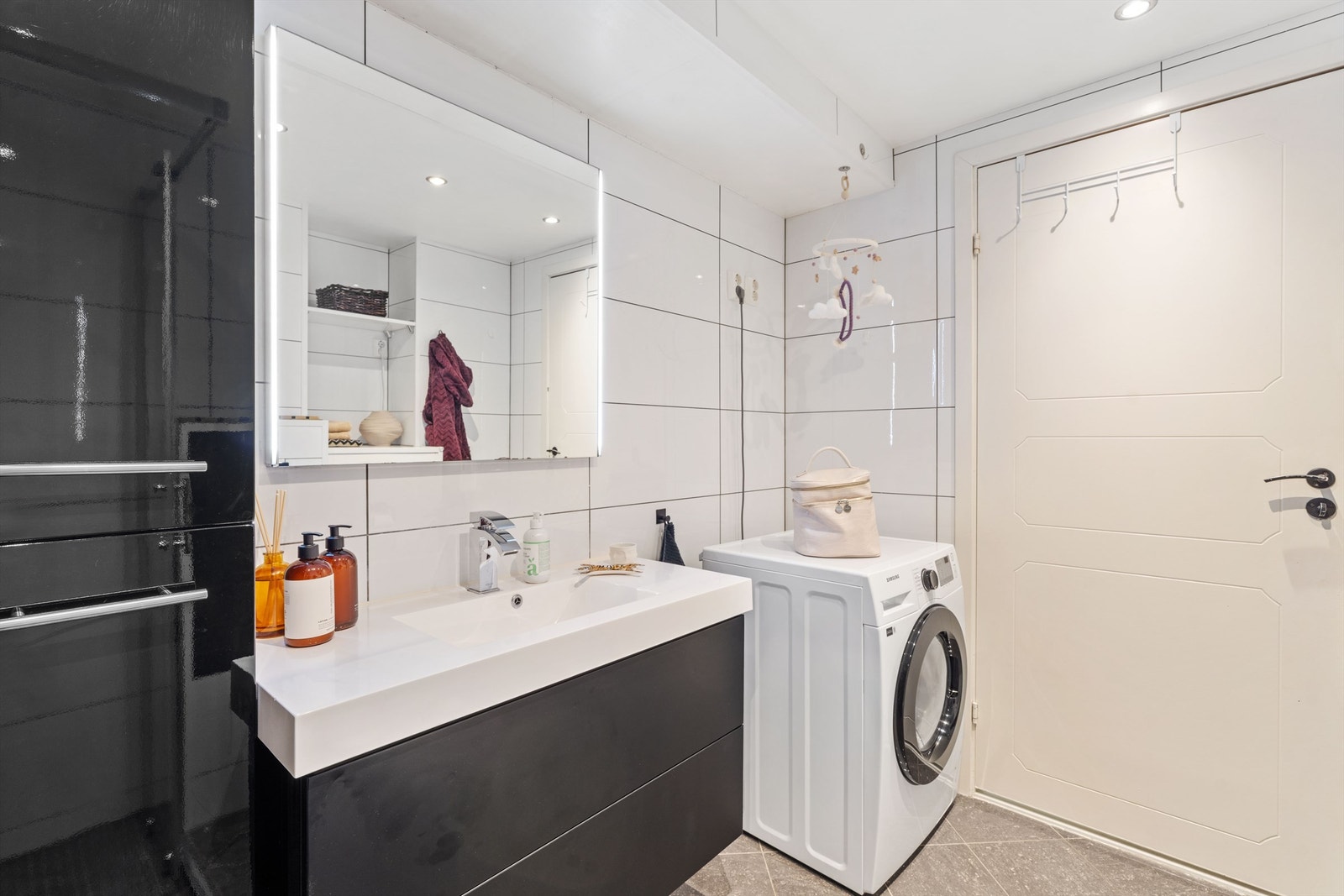 Her er det vegghengt toalett, servantinnredning og praktisk opplegg for vaskemaskin. Galleribilde