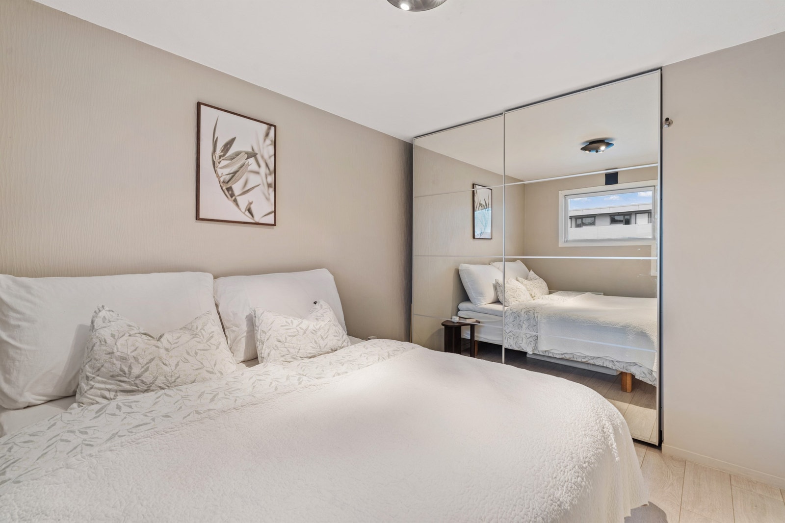 En stor skyvedørsgarderobe med speilfronter gir rikelig med oppbevaringsplass. Galleribilde