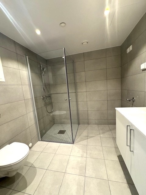 Stor bad med dusjhjørne og opplegg for vaskemaskin. Galleribilde