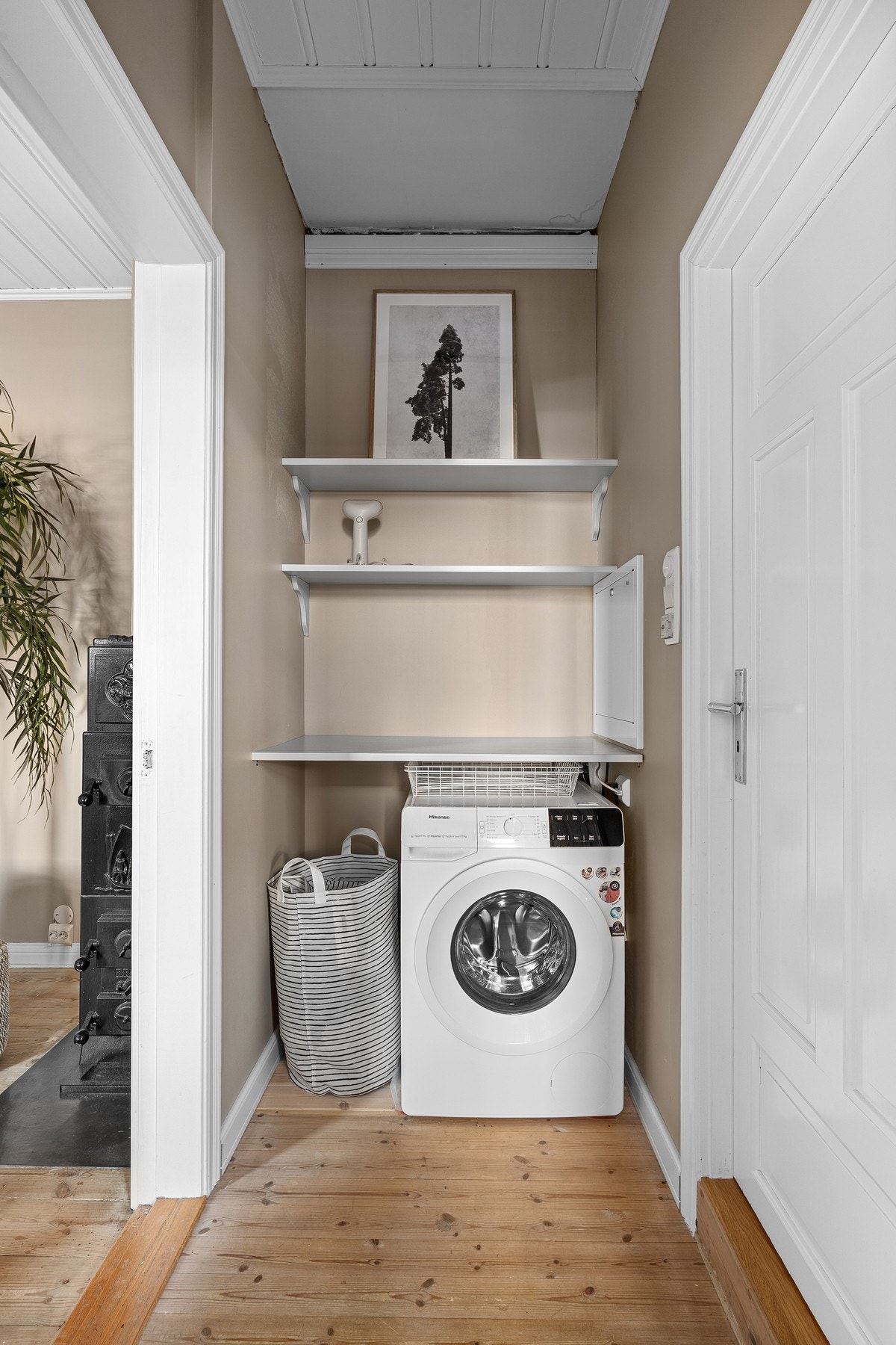 Mellomgang med opplegg for vaskemaskin og praktiske oppbevaringshyller Galleribilde