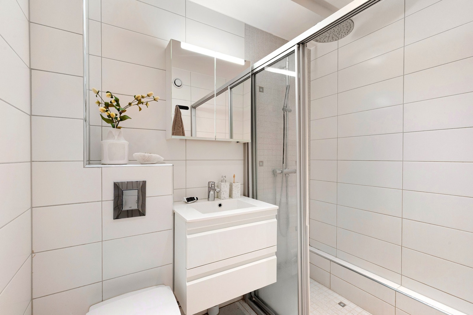 Pent bad, flislagt i tidløs stil med varmekabler i gulvet og downlights. Galleribilde