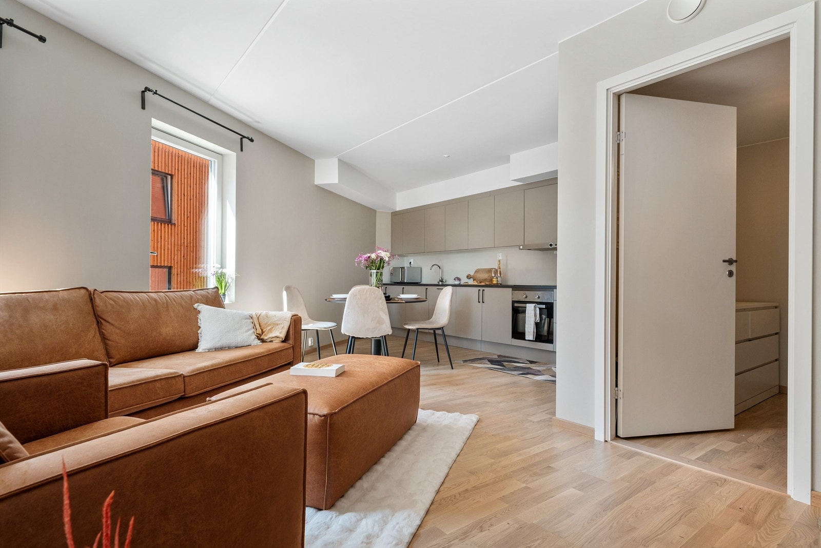 Leiligheten har en åpen løsning mot kjøkkenet, som sammen danner et gjennomgående og innbydende allrom. Galleribilde