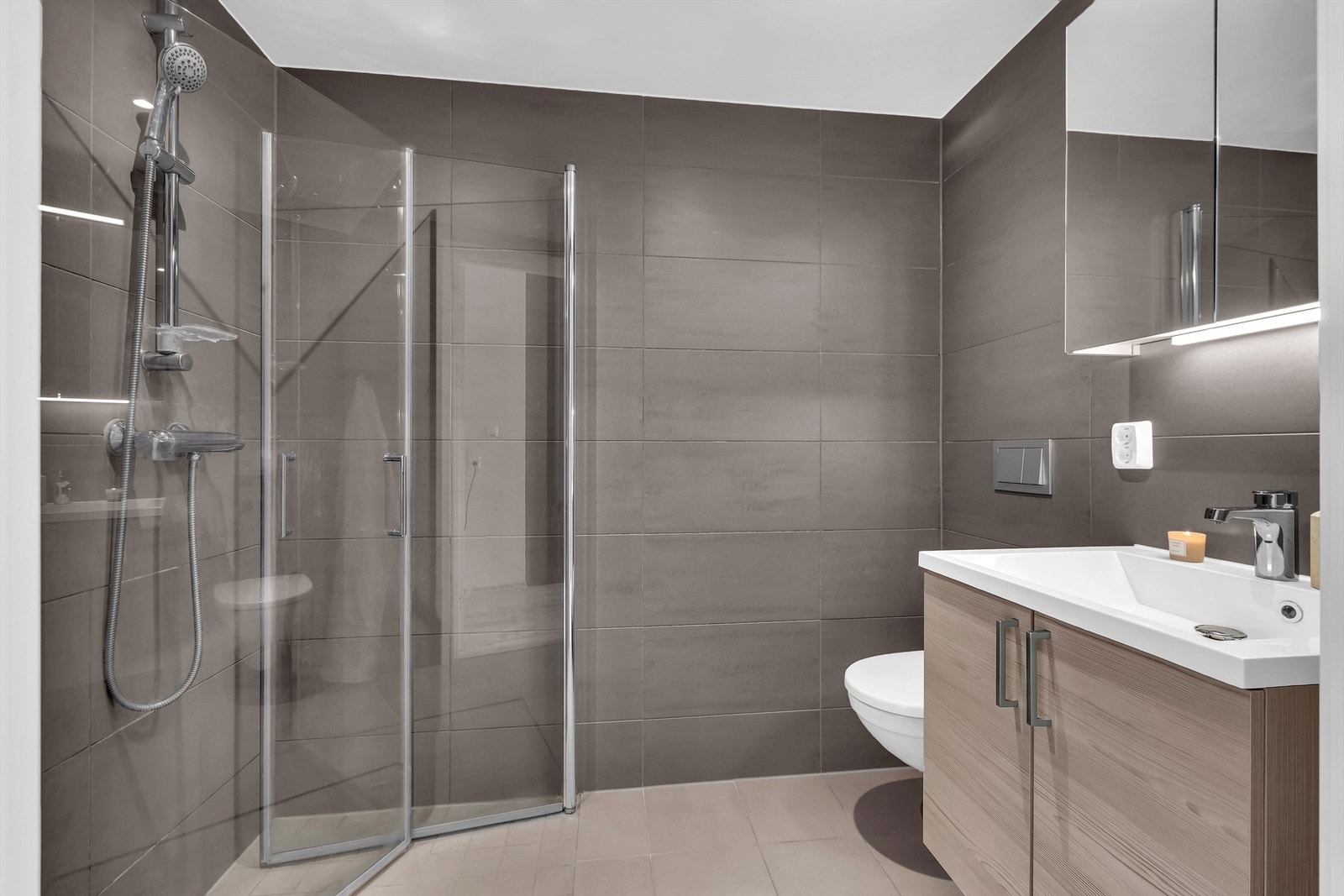 Baderom 2 med inngang fra hovedsoverommet er fra byggeår og har flislagt gulv med gulvvarme og flislagte vegger. Galleribilde