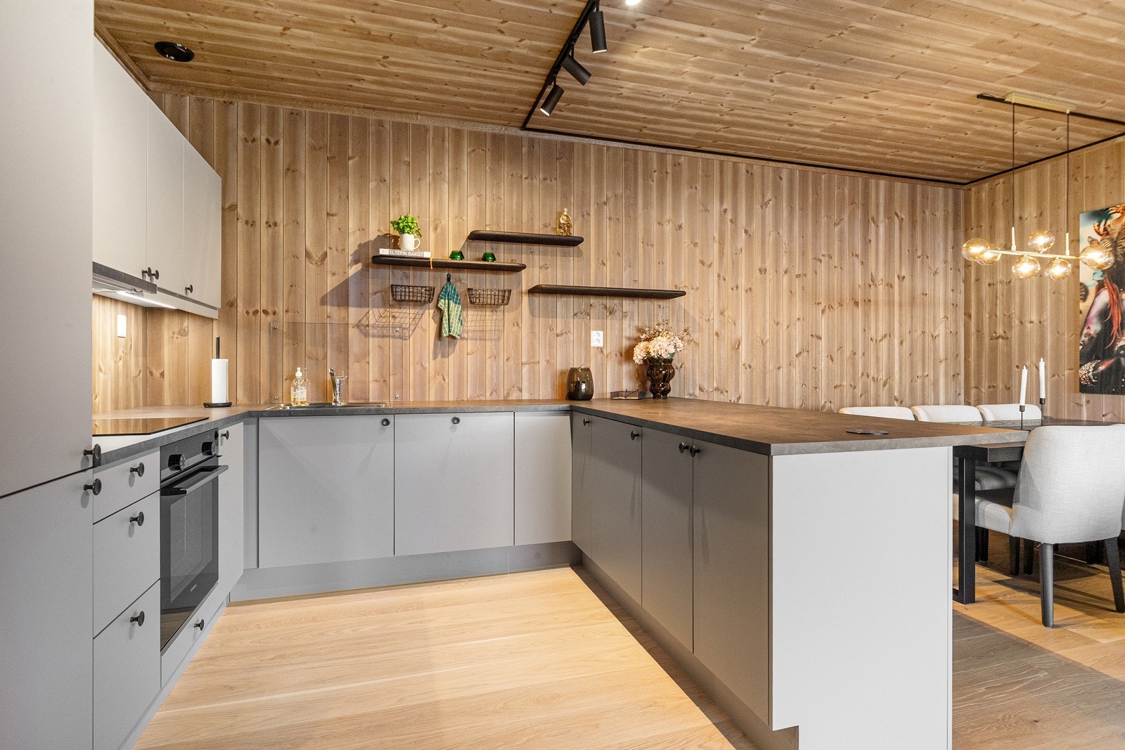 Leiligheten har åpen løsning mellom stue og kjøkken. Kjøkkenet med slette fronter, laminat benkeplate og integrerte hvitevarer Galleribilde