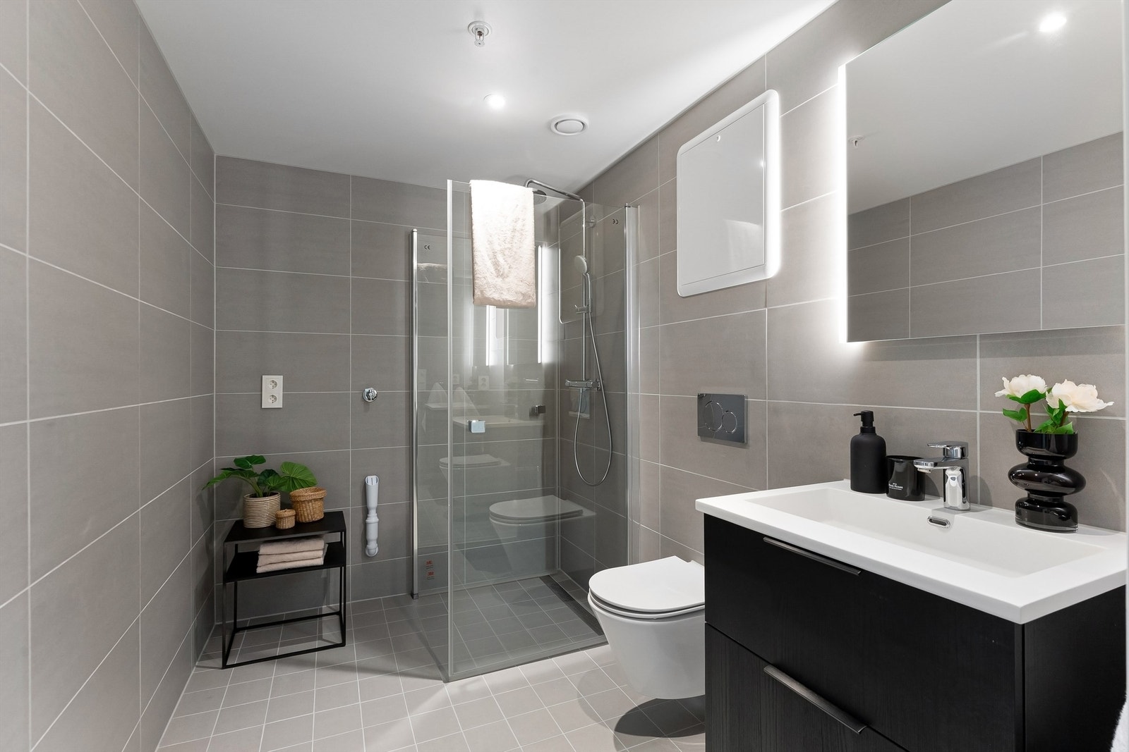 Pent og flislagt baderom med gulvvarme, downlights og opplegg for vaskemaskin og tørketrommel. Regnfallsdusj Galleribilde