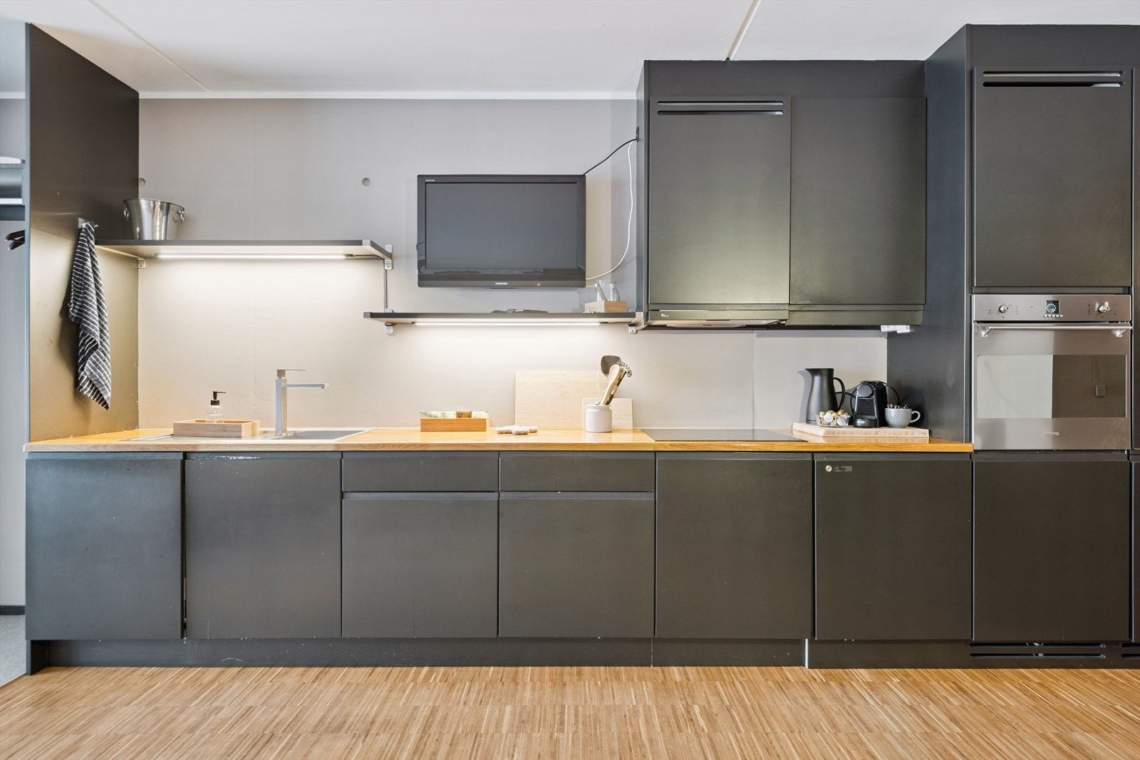 Moderne kjøkken med integrerte hvitevarer og en robust benkeplate i heltre. Galleribilde