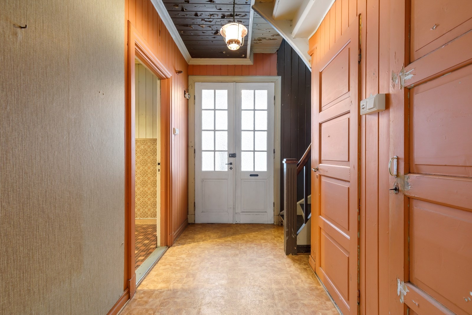 Hjemmets inngangsparti har adkomst trapp fra gårdsplass på det syd-vest, og vel innenfor boligens dobbeltfløyede og eldre hovedinngangsdør, møter man hjemmets kombinerte entrè og hall. Galleribilde