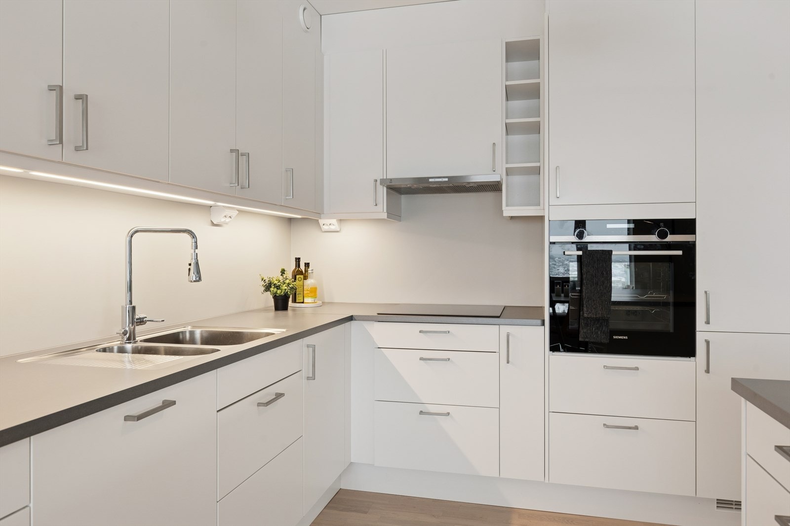 Kjøkkeninnredningen har slette fronter, laminert benkeplate og integrerte kvalitetsprodukter som stekeovn, platetopp og oppvaskmaskin. Galleribilde