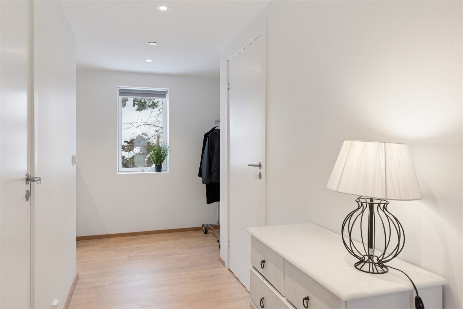 Den innbydende gangen setter tonen for resten av boligen med lyse flater og spotter i himling. Galleribilde