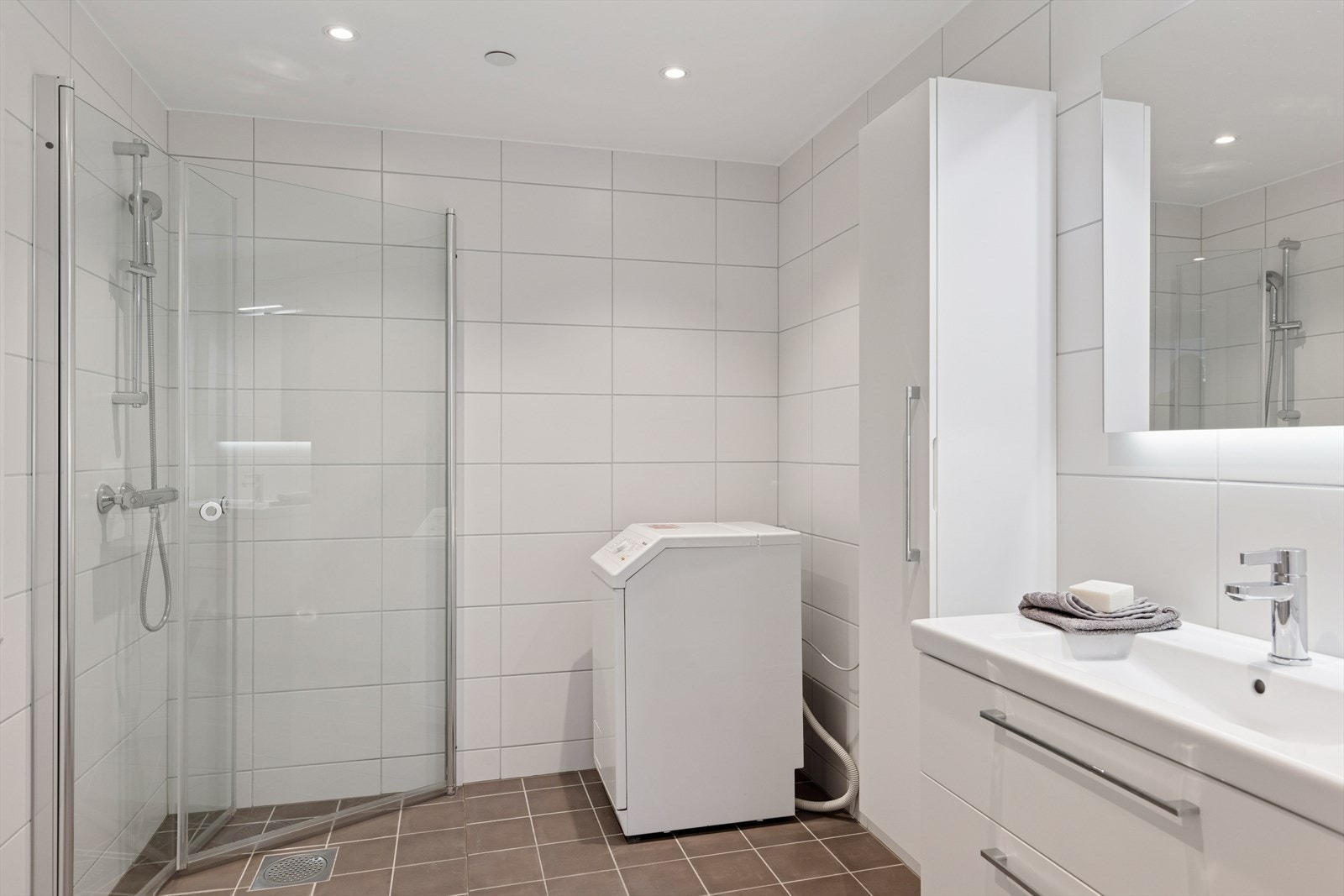 Badet holder en gjennomført kvalitet med fliser på vegg, flislagt gulv med varmekabler og moderne innredning. Galleribilde