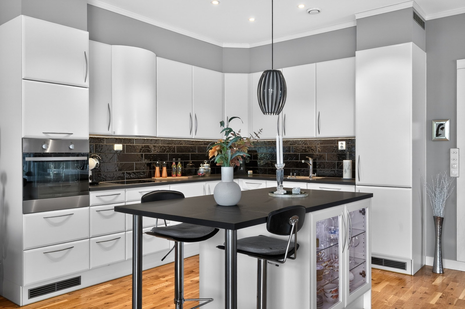 Kjøkkenet ligger naturlig tilbaketrukket fra stuen og er innredet med lyse, slette flater og benkeplate i kontrast. Galleribilde