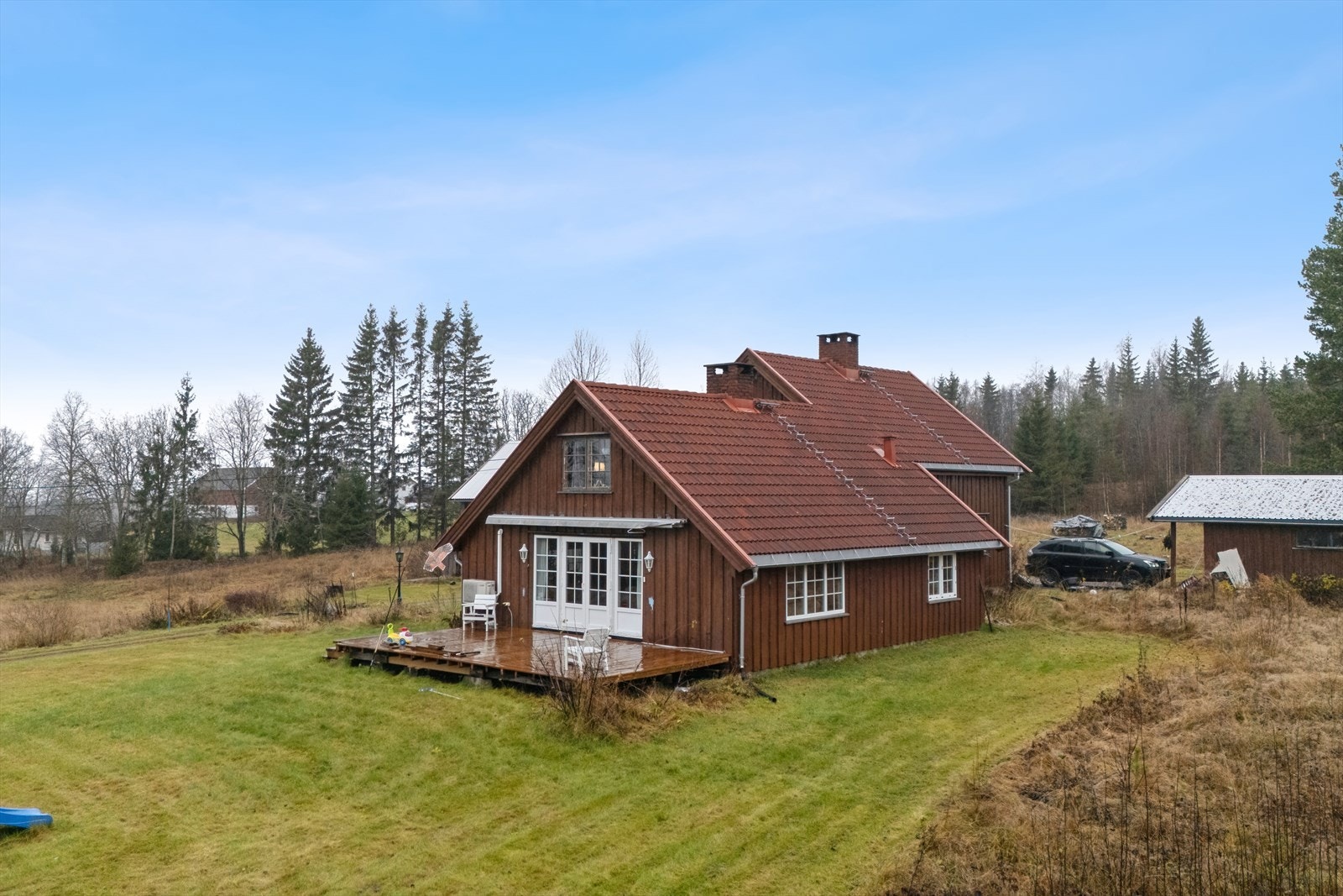 Bolighus med utgang til terrasse og romslig plenareal fra stue Galleribilde