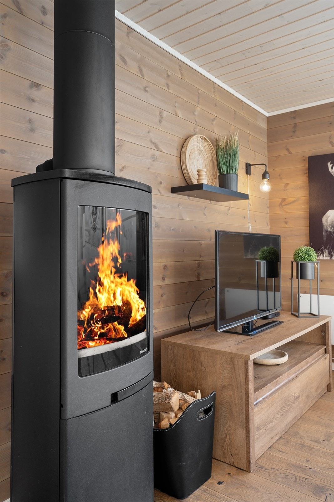 Den dekorative peisovnen gir hygge og varme på kalde vinterdager. Det er også montert en varmepumpe i hytten som sørger for en jevn og behagelig innetemperatur. Galleribilde