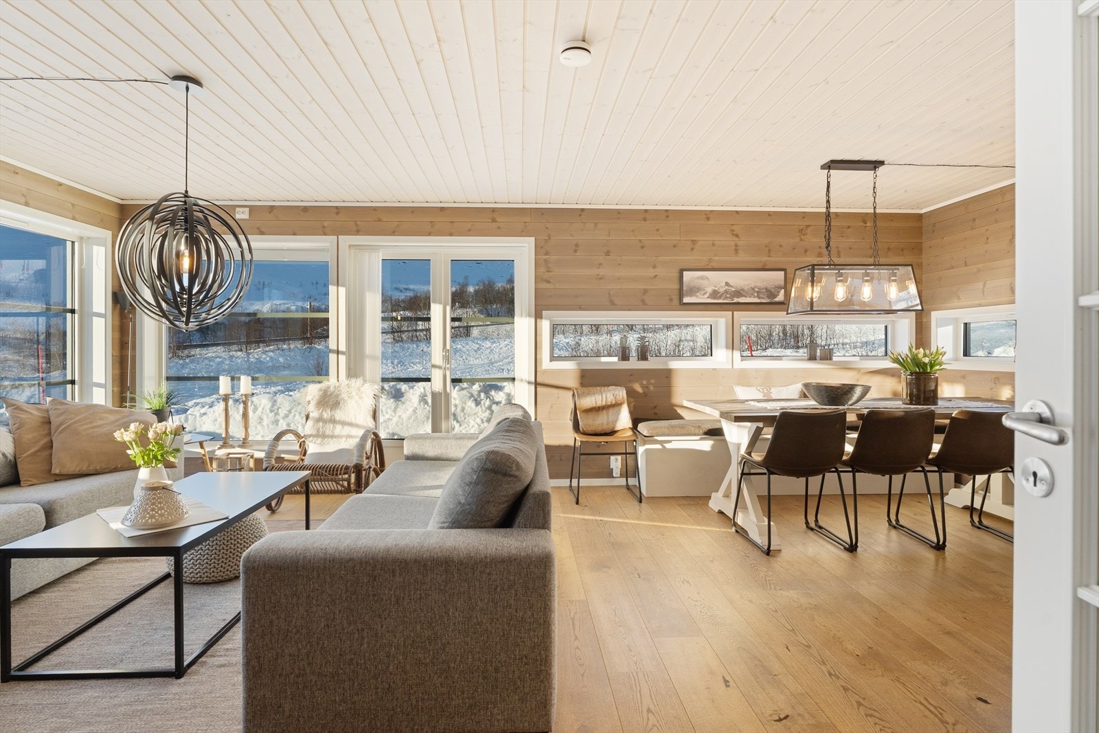 Stue og kjøkken i åpen løsning skaper en romslig og sosial arena. Lune materialvalg gir en behagelig atmosfære. Galleribilde