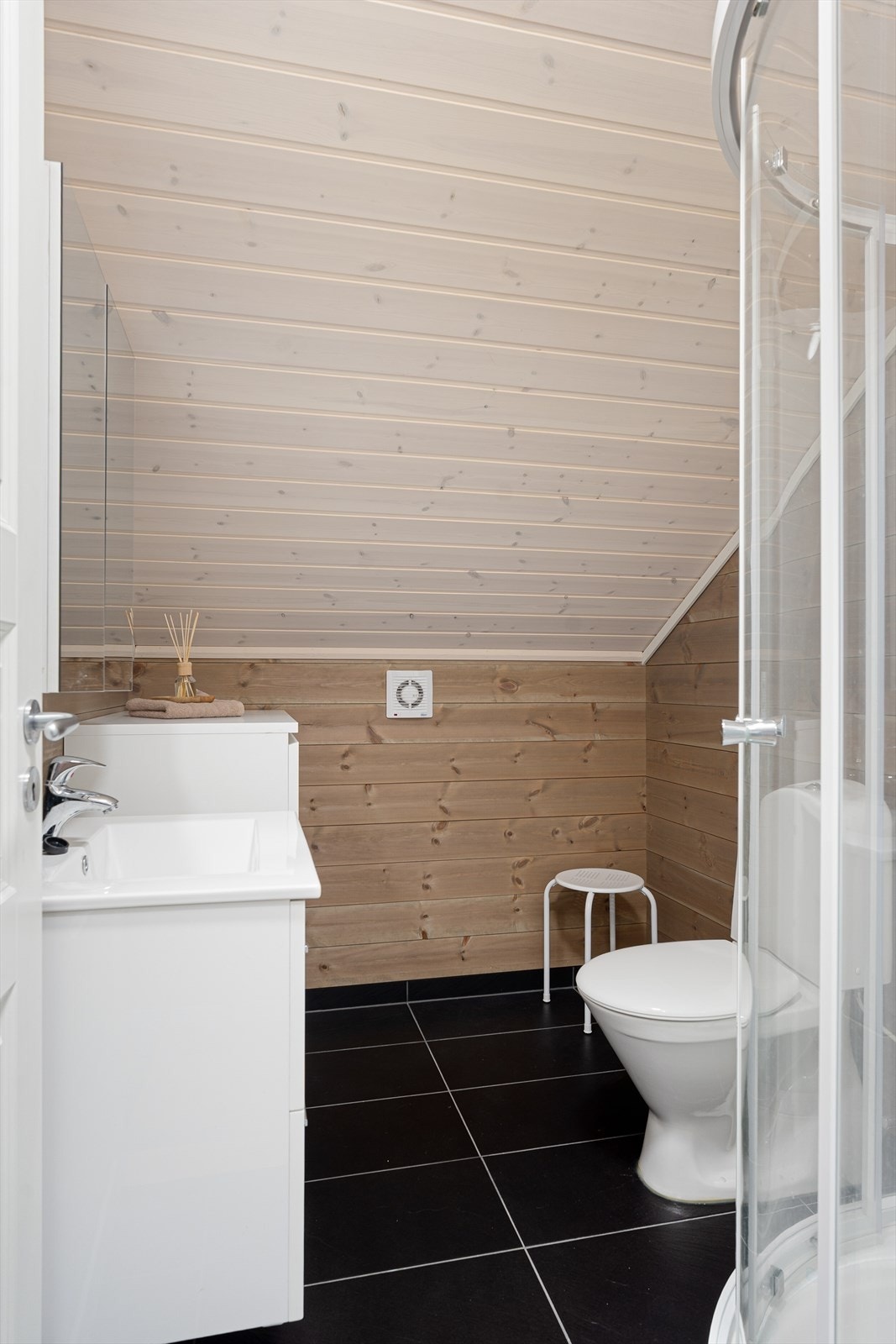 Rommet har flislagte gulv og panel på veggene. Det er varmekabel i gulvet. Galleribilde