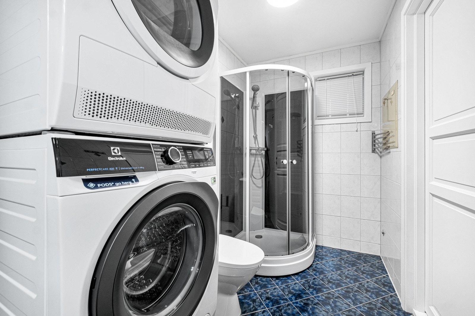 Badet er utstyrt med dusjkabinett og gulvstående toalett. Galleribilde