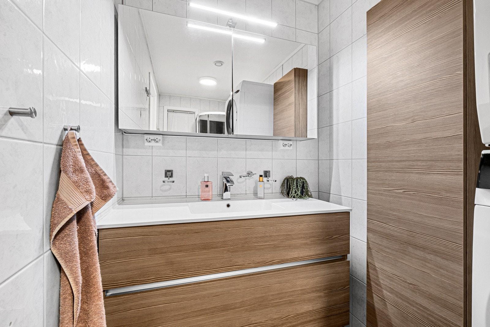 Stilren og moderne baderomsinnredning med mye oppbevaringsplass for baderomsartikler. Galleribilde