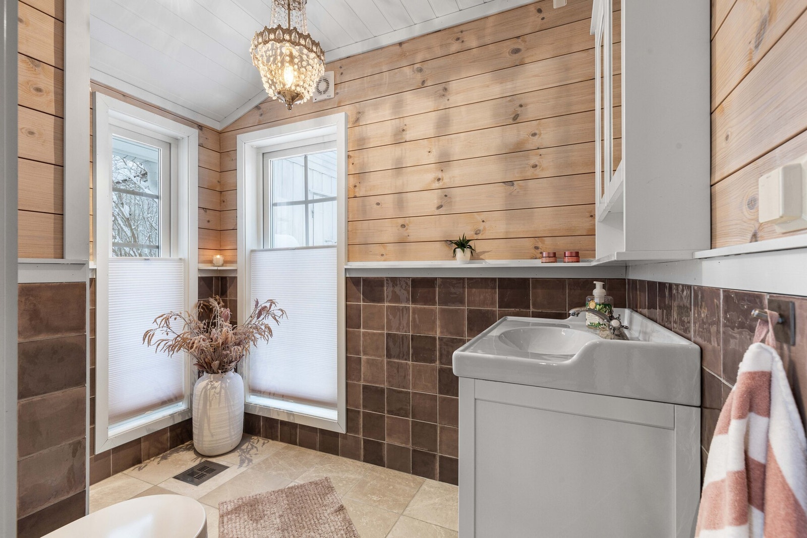 Delikat, delvis flislagt baderom fra 2019 med store vindusflater. Galleribilde