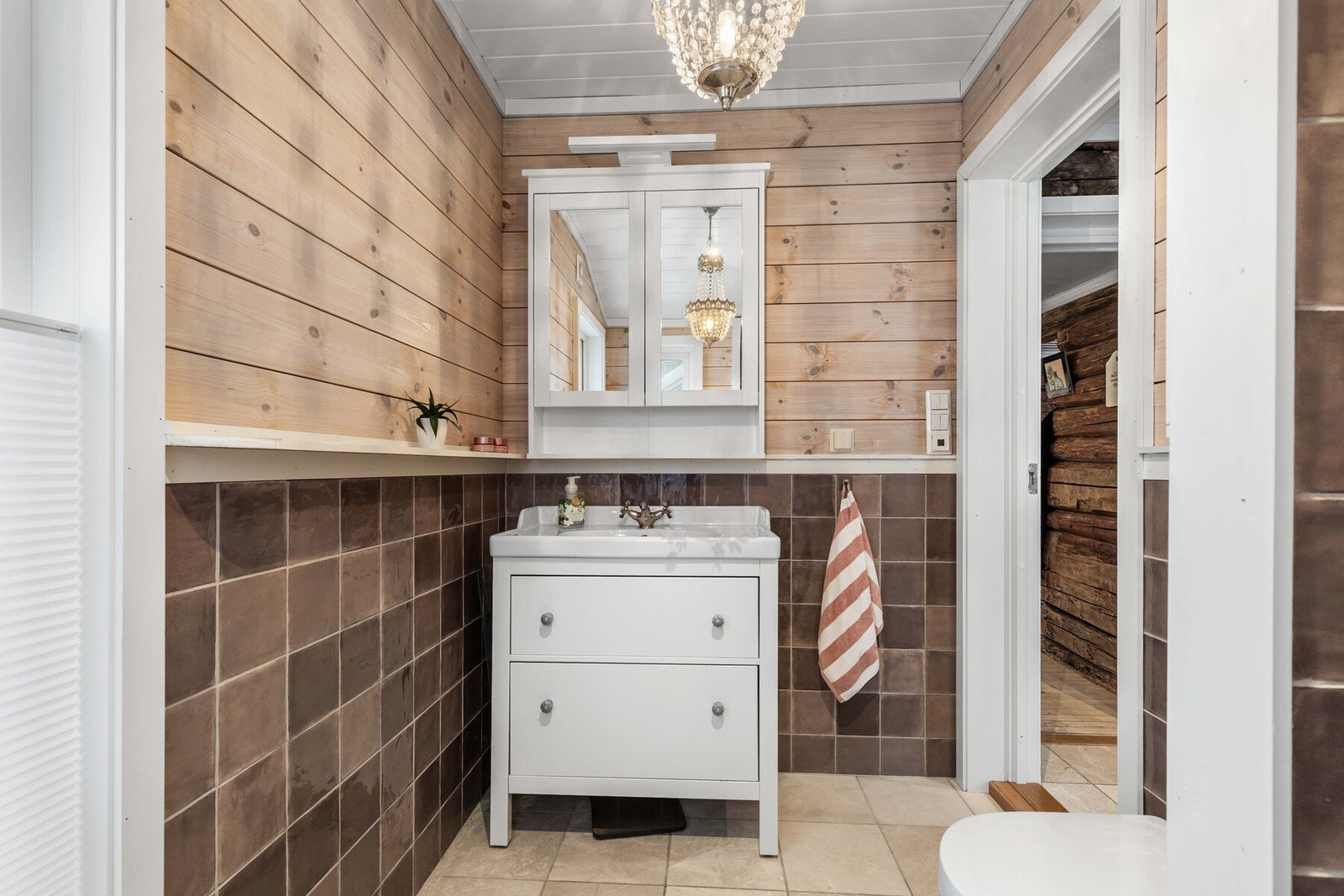 Baderommet inneholder servant, veggmontert wc og dusjnisje. Galleribilde