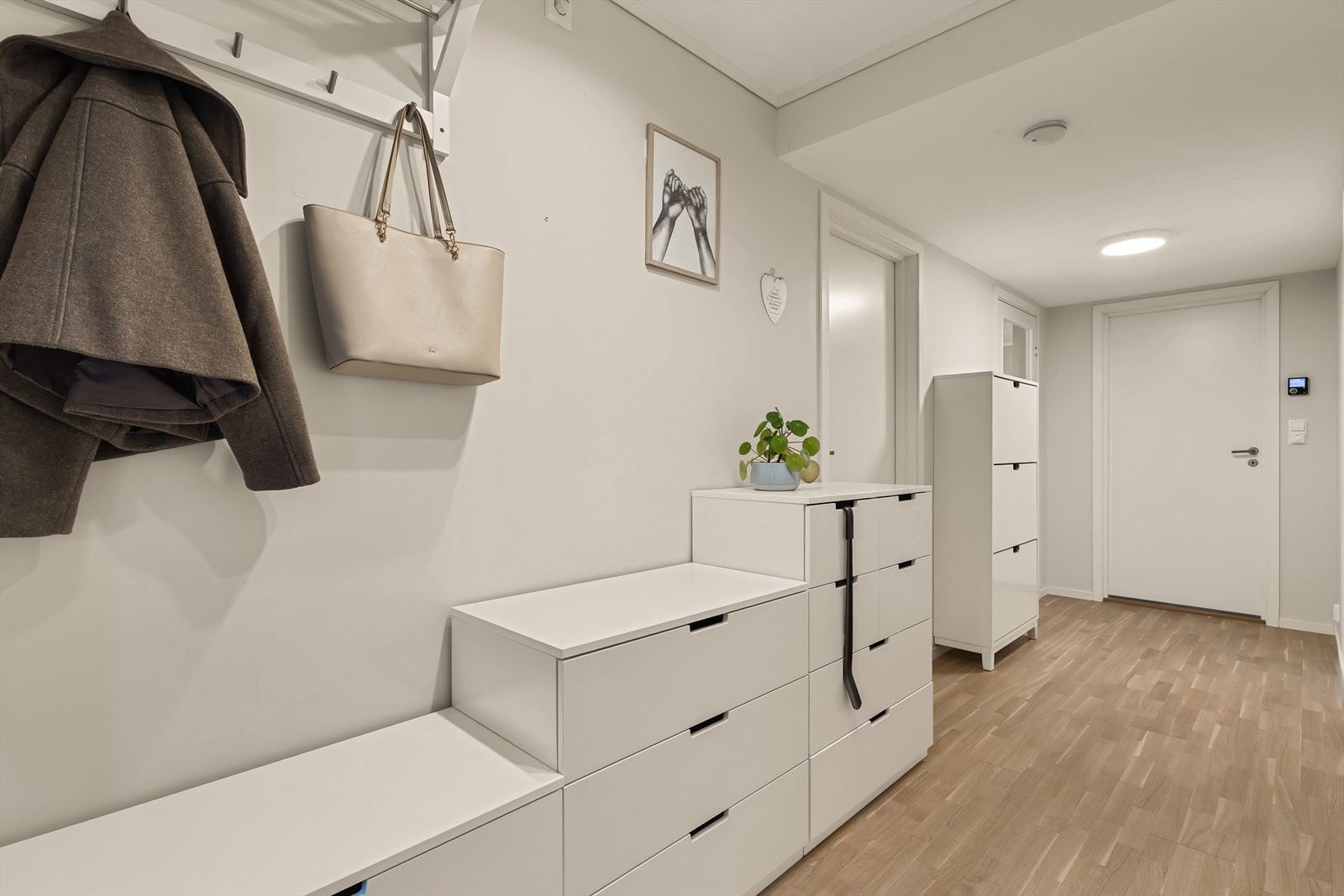 Lys og innbydende entré med parkett på gulv og malt platekledning på vegger/himling Galleribilde