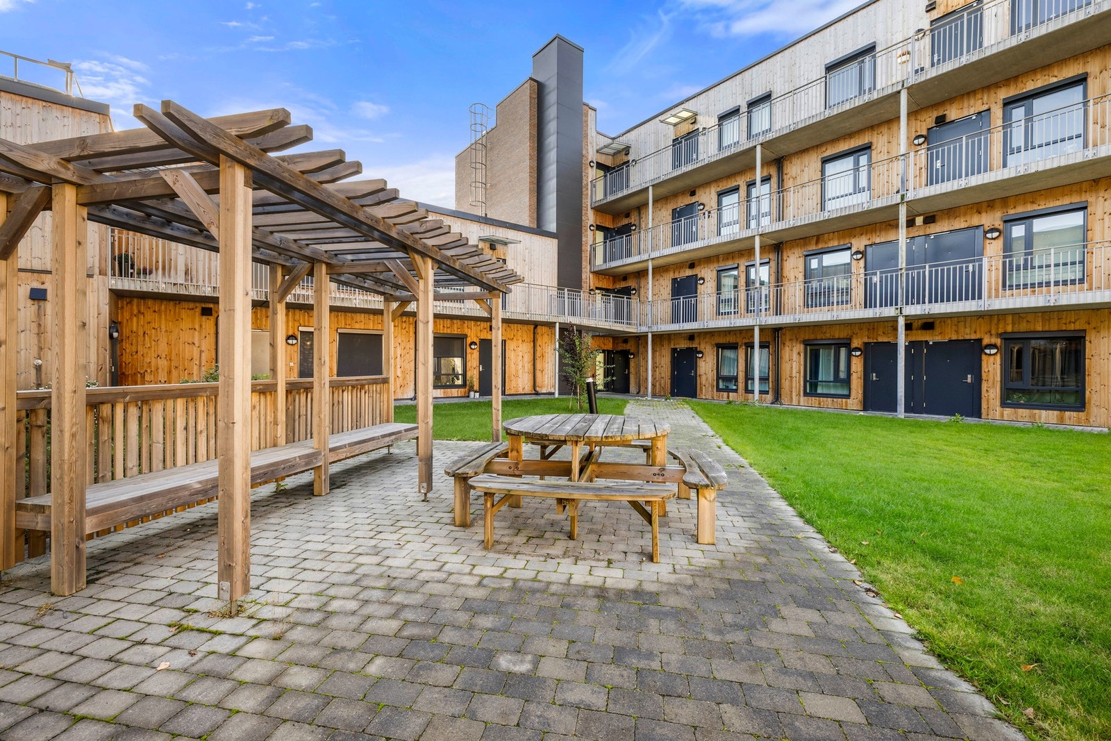 Grønne plenarealer skaper luft og rom mellom byggene, mens prydbusker og variert beplantning gir et frodig og velstelt uttrykk gjennom sesongene. Galleribilde