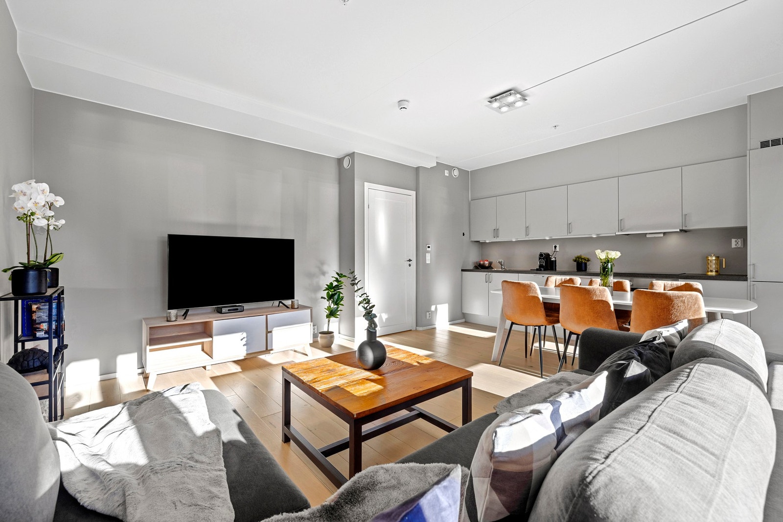 Mellom stue og kjøkken er det en naturlig og lun sone for spisebord, som gjør rommet ideelt for både hverdagsmiddager og sosiale middager med venner og familie. Galleribilde