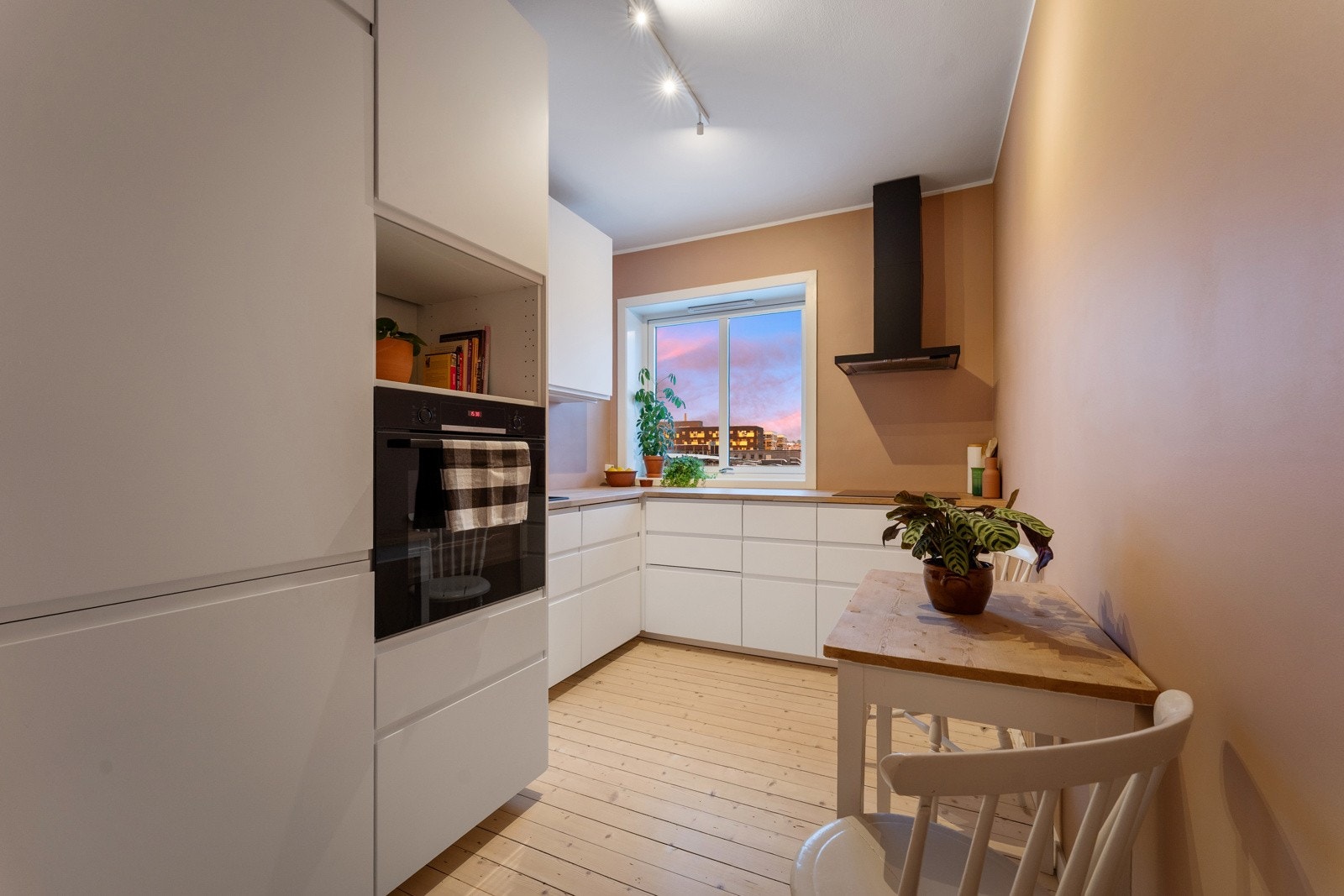 Separat kjøkken med innredning fra 2021, integrerte hvitevarer og plass til spisebord. Galleribilde