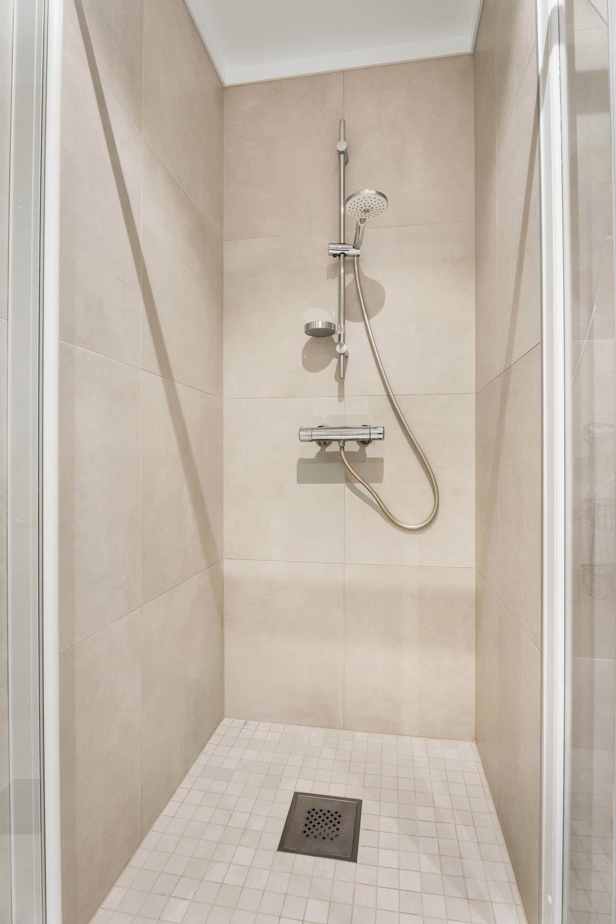 Innredning av skuffeseksjon med servant, speil og belysning, dusj, vegghengt toalett Galleribilde