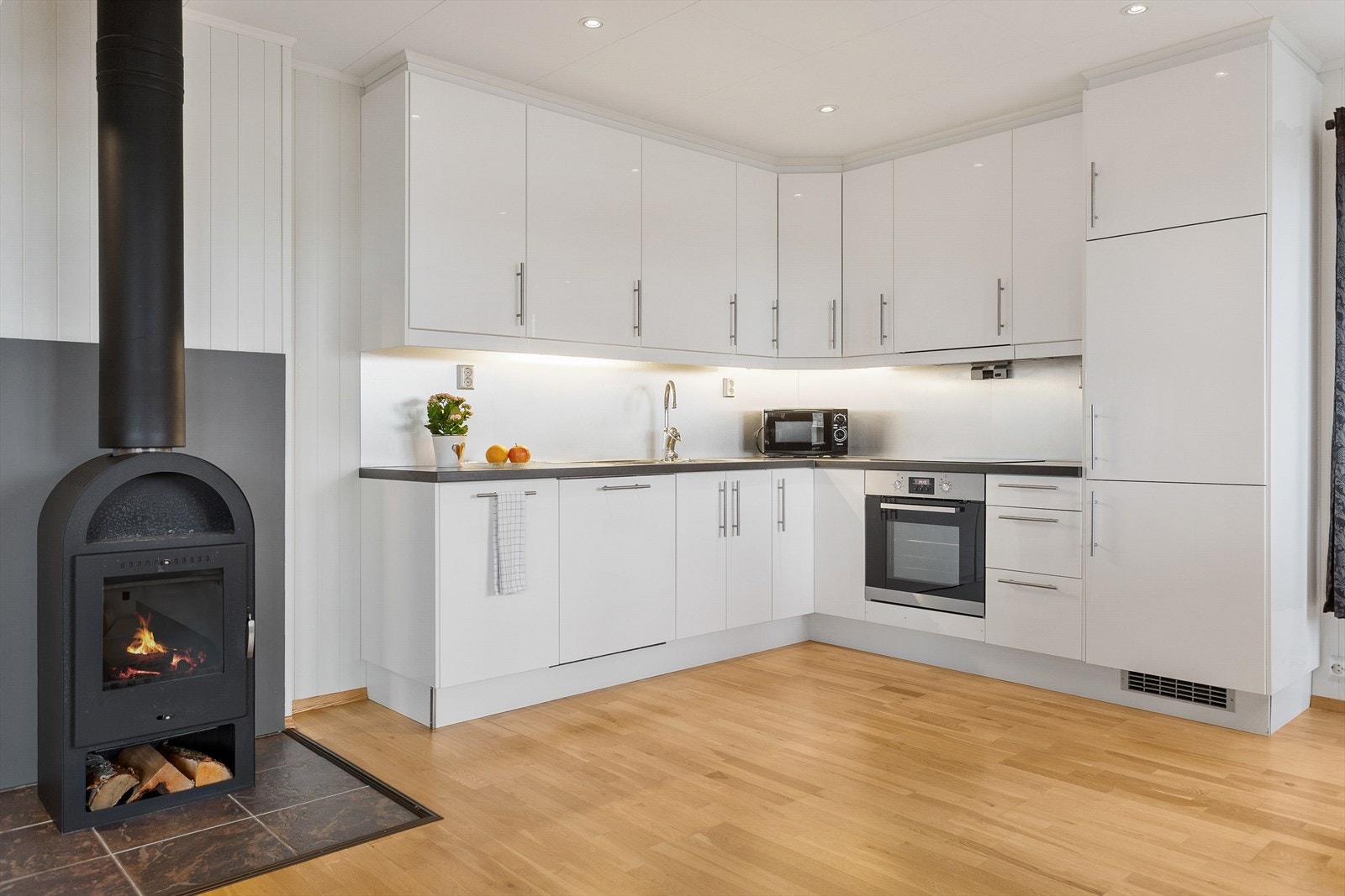 Kjøkkenet har glatte fronter og benkeplate av laminat, med integrerte hvitevarer Galleribilde