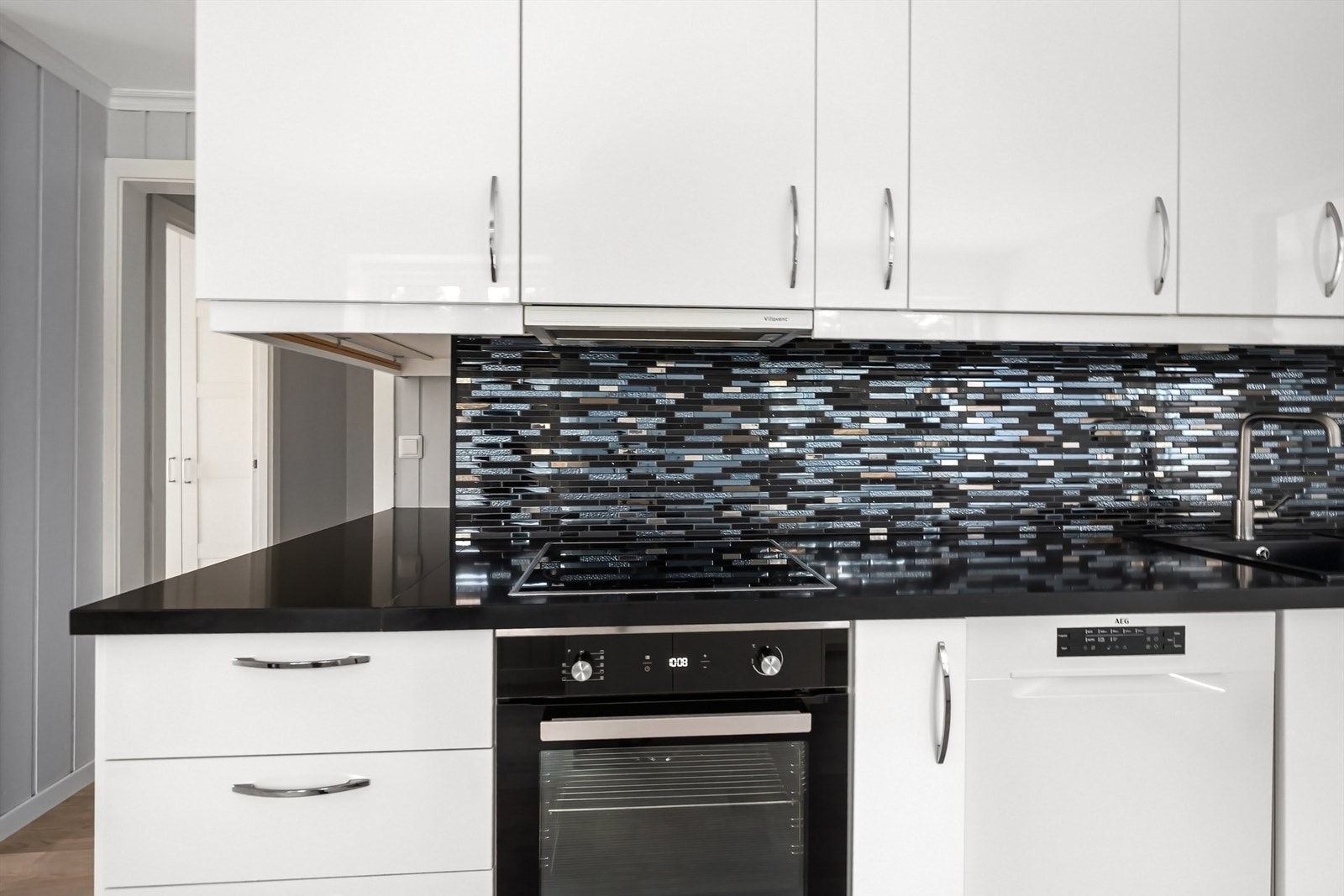 Mosaikkfliser over benken gir kjøkkenet et stilrent uttrykk. Galleribilde