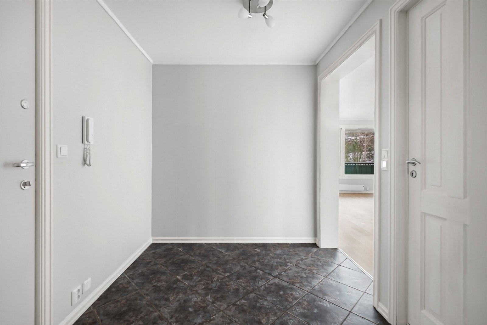 Innbydende entré med flislagt gulv og plass for yttertøy. Galleribilde