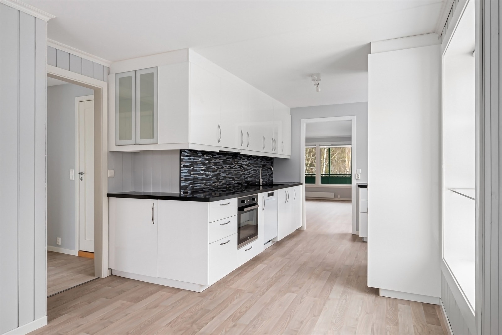 Innredningen har hvite, glatte fronter og en slitesterk benkeplate i kvartskompositt. Galleribilde