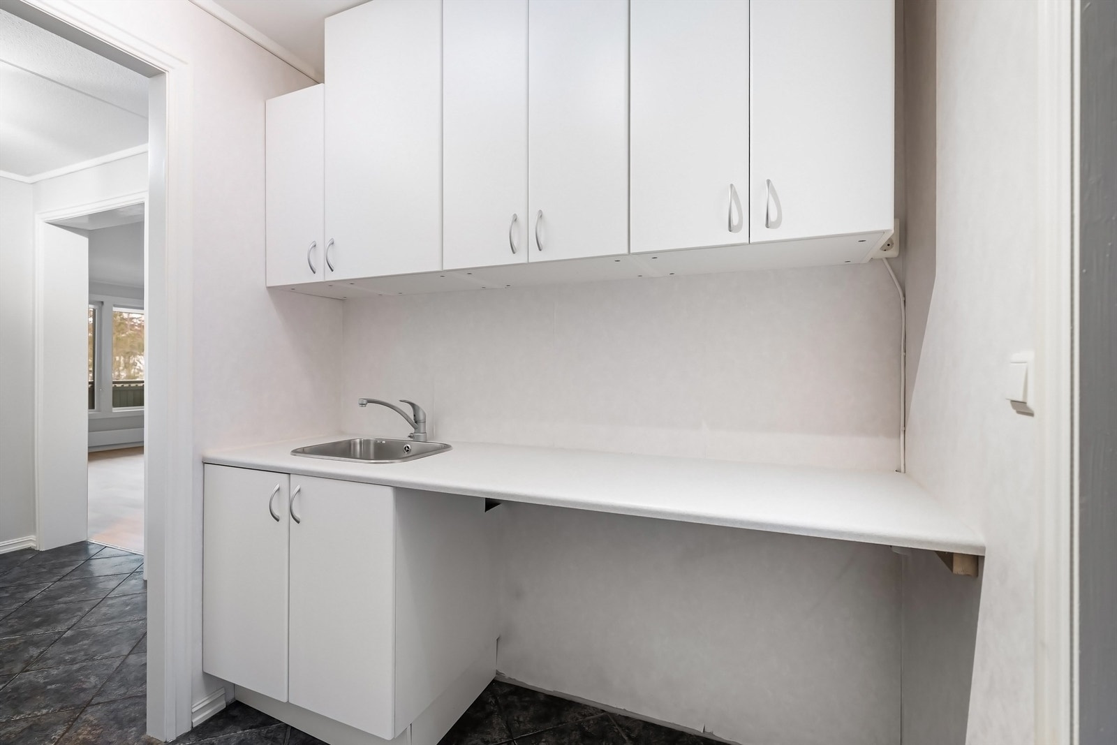 Her er det opplegg for vaskemaskin og tørketrommel, samt god oppbevaringsplass i over- og underskap. Galleribilde