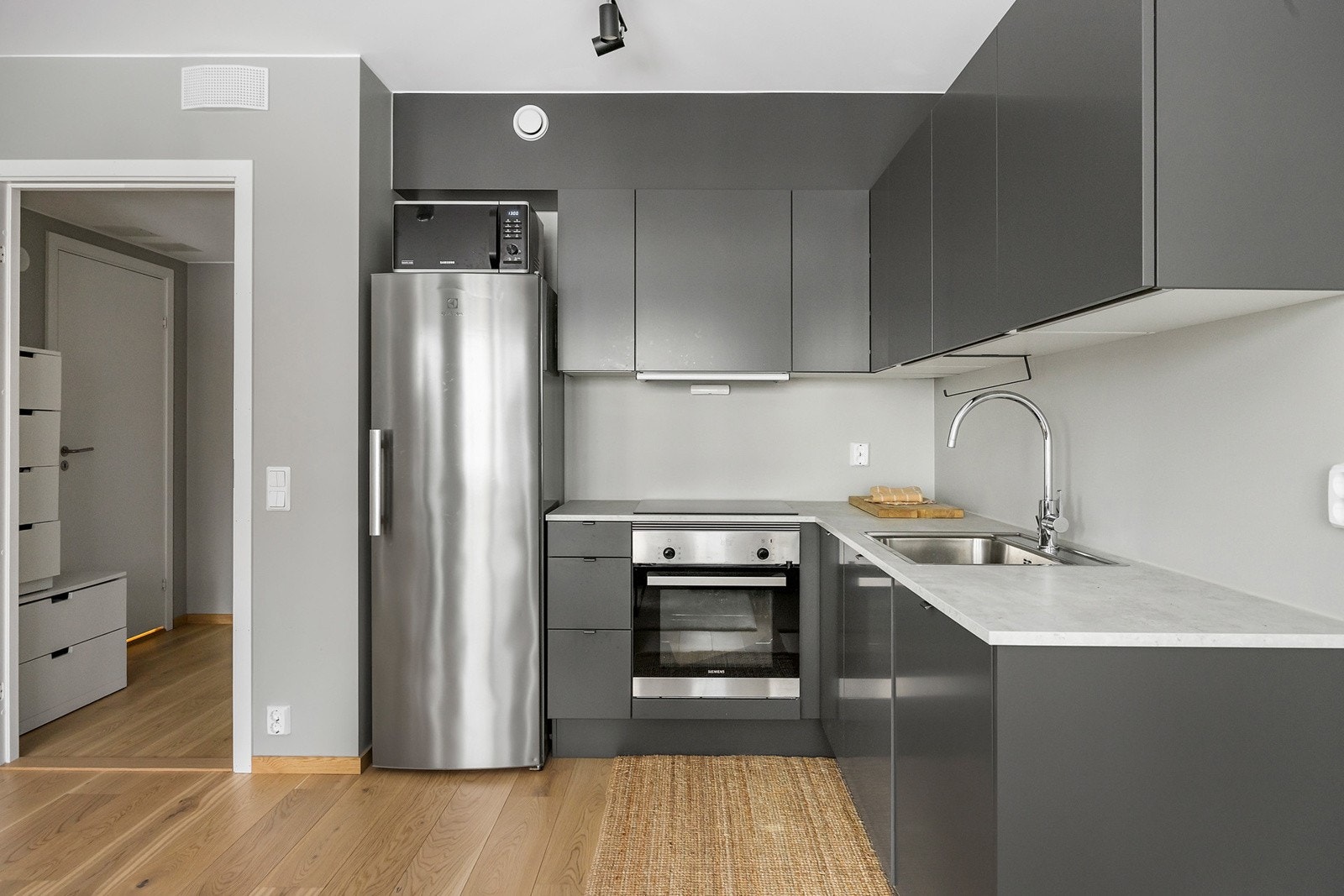 Delikat kjøkken fra HTH med mørk grå fronter. Godt med skap og benkeplass til matlaging. Galleribilde