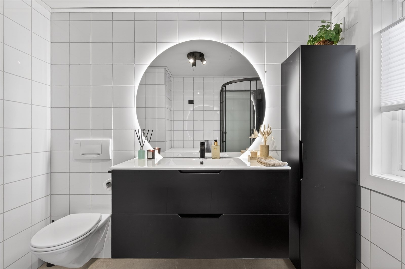 Badet er flislagt fra topp til tå, med vegghengt WC og ny servant med skuffer og servantskap. Galleribilde